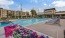 a swimming pool with flowers and a building in the background